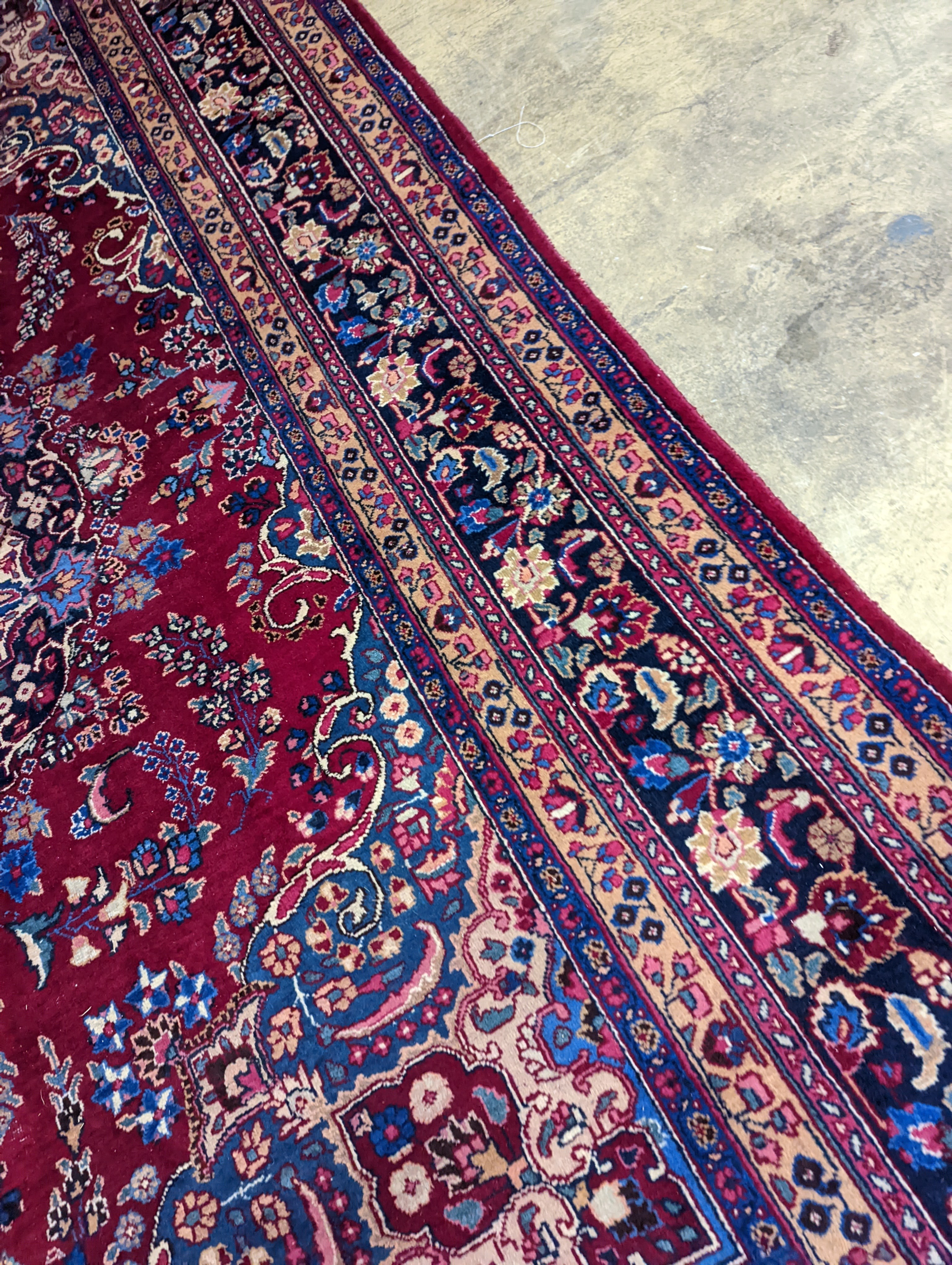 A Tabriz burgundy ground carpet, 350 x 250cm